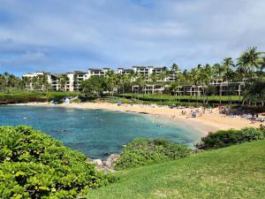 a beach with a bunch of people in the water at K B M Resorts- KGV-17T5 Remodeled 1Bdrm villa extra-large balcony sweeping ocean views in Kapalua