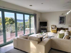 a living room with a couch and a balcony at Wildferns Lodge and Sailors Studio Opua in Opua