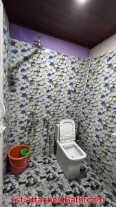 La salle de bains est pourvue de toilettes et d'un mur recouvert de rochers. dans l'établissement Homestay In Coorg Doddakallu Betta, à Somvārpet
