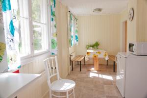 a kitchen with a table and a white refrigerator at Soltorp Eco Lodge in Porvoo