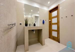 a bathroom with a shower with a sink and a mirror at Elk Room in Sopot