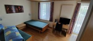 a small living room with a bed and a tv at Hotel / Restaurant Post in Eschlikon