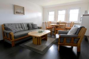 sala de estar con sofá, sillas y mesa en FeWo Birkenweg, en Schneverdingen