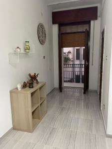 a hallway with a wooden table and a clock on the wall at Casa Vacanza Rosati in Cerignola