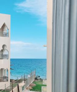uma vista para o oceano a partir de uma varanda de um edifício em Apart haut standing v mer em Sousse