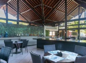 a restaurant with tables and chairs and a bar at Nannai Beira Mar, Flat Duplex em Muro Alto - Porto de Galinhas in Porto De Galinhas