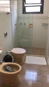 a bathroom with a toilet and a glass shower at Casa 251 in Pomerode