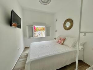 Habitación blanca con cama y TV en Eden Gomera Suites en Agulo