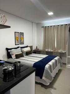 a bedroom with a large bed with a blue blanket at Studio no West Fit Mossoró Alto Padrão in Mossoró