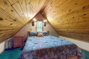 a bedroom with a large bed in a wooden ceiling at Christina Cabin in Girdwood