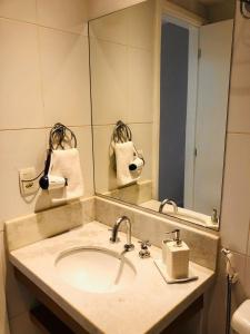 baño con lavabo y espejo grande en Apê pratico, com wi fi, ar na Nova Barra da Tijuca, en Río de Janeiro