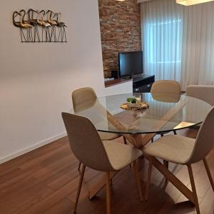 une salle à manger avec une table et des chaises en verre dans l'établissement Casa da Praça, à Miranda do Douro
