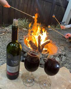 two glasses of red wine next to a fire at Chalés Refúgio Ohana in Urubici