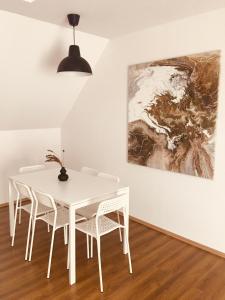 a white dining room with a white table and chairs at Pataky Apartmanok in Veszprém