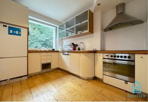 a kitchen with white cabinets and a large window at Funky Room in Sopot