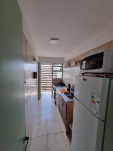La cuisine est équipée d'un réfrigérateur blanc et d'un évier. dans l'établissement Temporario 3B, à Resistencia