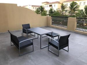 una mesa y sillas en un patio en Alwaha luxury Villa 5 Bedrooms فيلا الواحه en King Abdullah Economic City