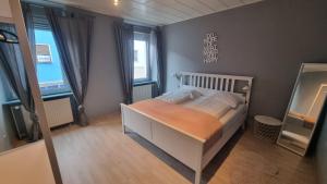 a bedroom with a white bed with an orange blanket at Sander's Apartments Landstuhl in Landstuhl