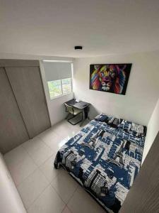 a bedroom with a bed and a painting on the wall at Apartamento en Bucaramanga in Bucaramanga