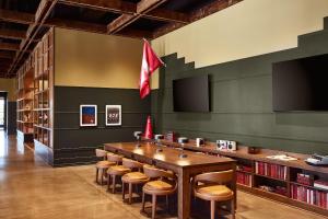 a library with a large wooden table and stools at The Scarlet, Lincoln, a Tribute Portfolio Hotel in Lincoln +37 photos
