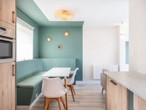 a kitchen with blue walls and a table and chairs at Cottage B10 in Koksijde