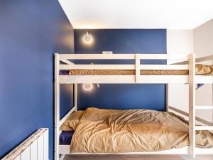 a bunk bed in a room with a blue wall at Cottage B10 in Koksijde