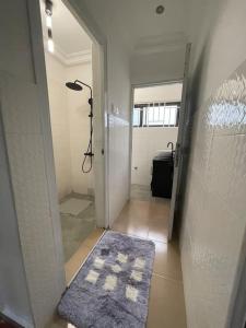 a hallway with a walk in shower and a blue rug at Modern Family House with 2 bedrooms + Free Parking in Ashaiman