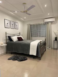 a bedroom with a bed and a ceiling fan at Modern Family House with 2 bedrooms + Free Parking in Ashaiman