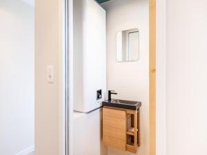 a bathroom with a sink and a refrigerator at Cottage B10 in Koksijde