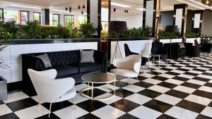 a lobby with a couch and chairs on a checkered floor at Hotel Puerto Palace in Puerto de la Cruz