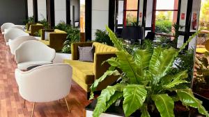 a lobby with a bunch of chairs and plants at Hotel Puerto Palace in Puerto de la Cruz