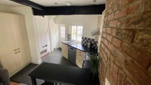a kitchen with a brick wall next to a table at 2 Bed House in Knaresborough in Knaresborough