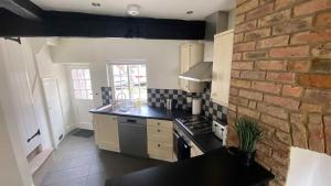 a kitchen with a brick wall and a stove top oven at 2 Bed House in Knaresborough in Knaresborough