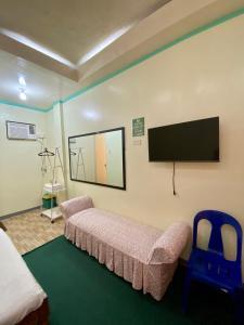 Zimmer mit einem Bett und einem Flachbild-TV in der Unterkunft Anda Seabreeze Pension Haus in Anda