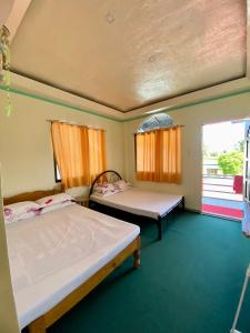 Zimmer mit 2 Betten und einem Fenster in der Unterkunft Anda Seabreeze Pension Haus in Anda