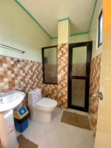 łazienka z toaletą i umywalką w obiekcie Anda Seabreeze Pension Haus w mieście Anda