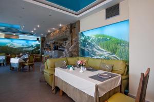 a dining room with a table and a couch at Yug Hotel in Krasnodar
