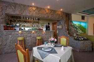 a dining room with a table and a bar at Yug Hotel in Krasnodar