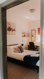 um quarto com uma cama e uma secretária com uma cadeira em Hylton - 3 Bdrm Apt City Ctre sleeps 5 Ideal for Contractors em Pallion