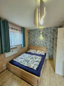 sypialnia z łóżkiem z niebieską kołdrą w obiekcie Noclegi nad jeziorem BUDEX w Nysie