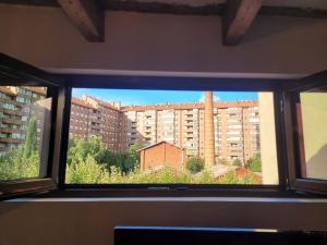 een raam met uitzicht op een groot gebouw bij El Ático de Entrevías - Apartamento con garaje y WIFI in León