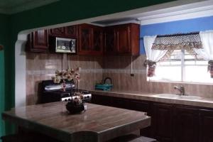 a kitchen with a table and a sink and a window at Hill View Villas in Bamboo