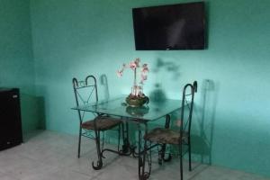 a glass table with chairs and a vase with flowers on it at Hill View Villas in Bamboo
