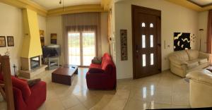 克雷馬斯蒂的住宿－Luna's Summer House，客厅配有红色椅子和电视
