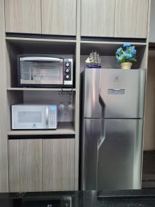 a kitchen with a stainless steel refrigerator and a microwave at Angra dos Reis, Angra Inn, Cantinho perfeito in Angra dos Reis