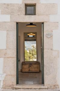 a door in a brick wall with a window at Masseria Gorgognolo in Ostuni