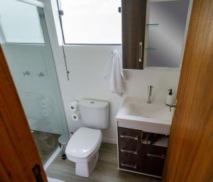 a bathroom with a toilet and a sink and a shower at Suítes Container in Pomerode