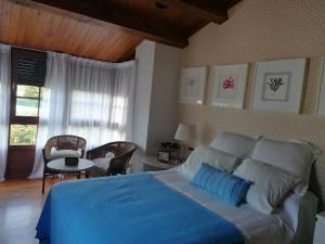 a bedroom with a large bed with a blue blanket at Casa Bonita in Mugardos