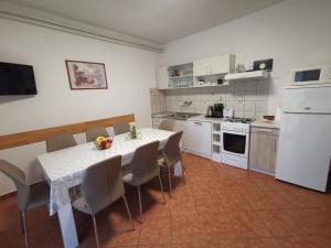 a kitchen with a table and chairs and a kitchen with white appliances at Apartment Feruco in Kršan