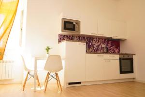 a kitchen with white cabinets and a table and a microwave at Centrally Located Gem in Prague in Prague